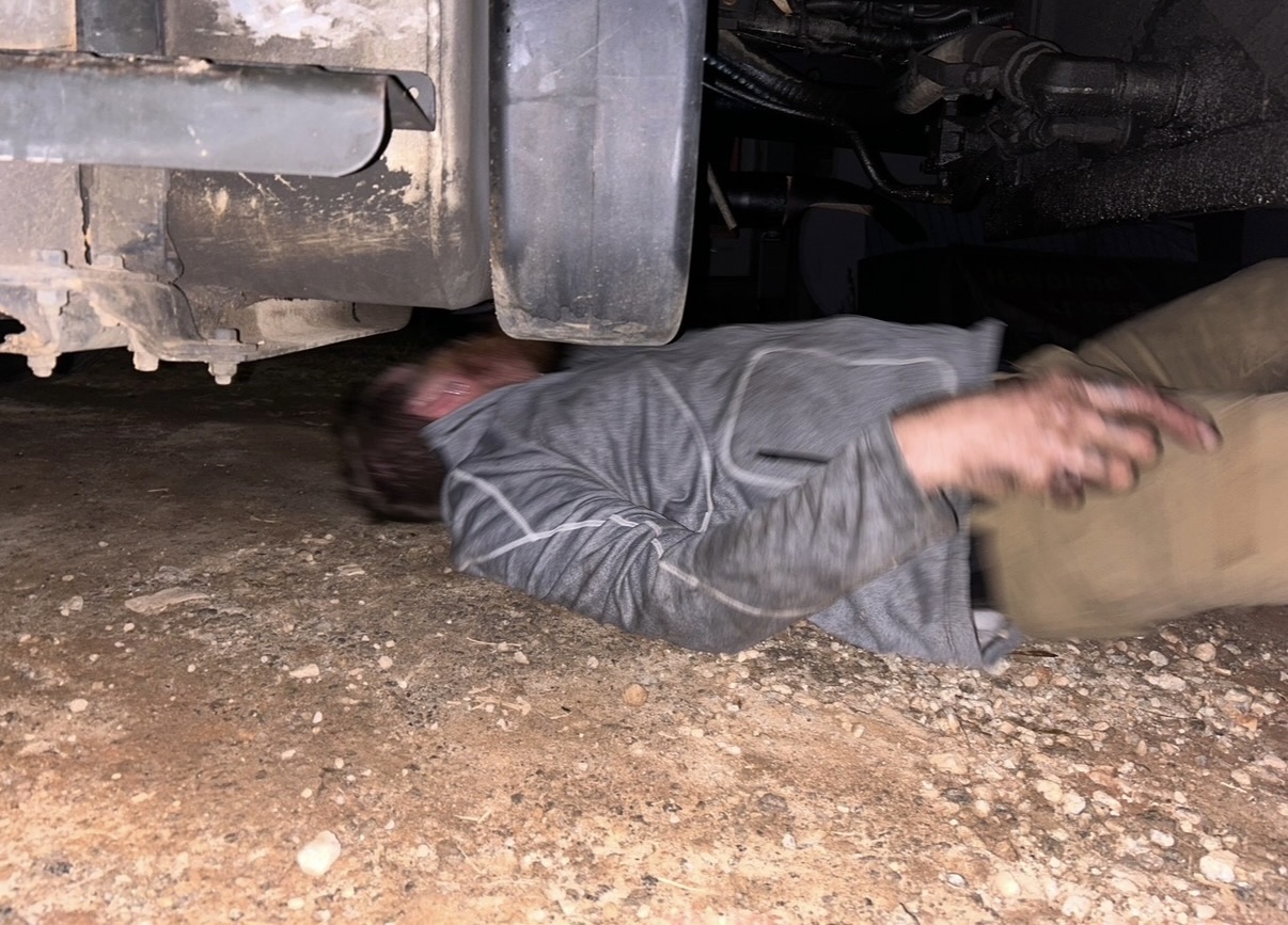 Michael underneath a truck at night on a first service call