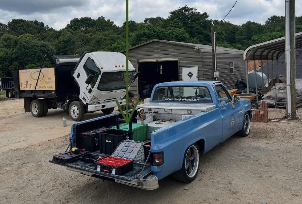 Gunnells Services truck bed with the green Rubbermaid tote and rolling tool cases on a fleet job