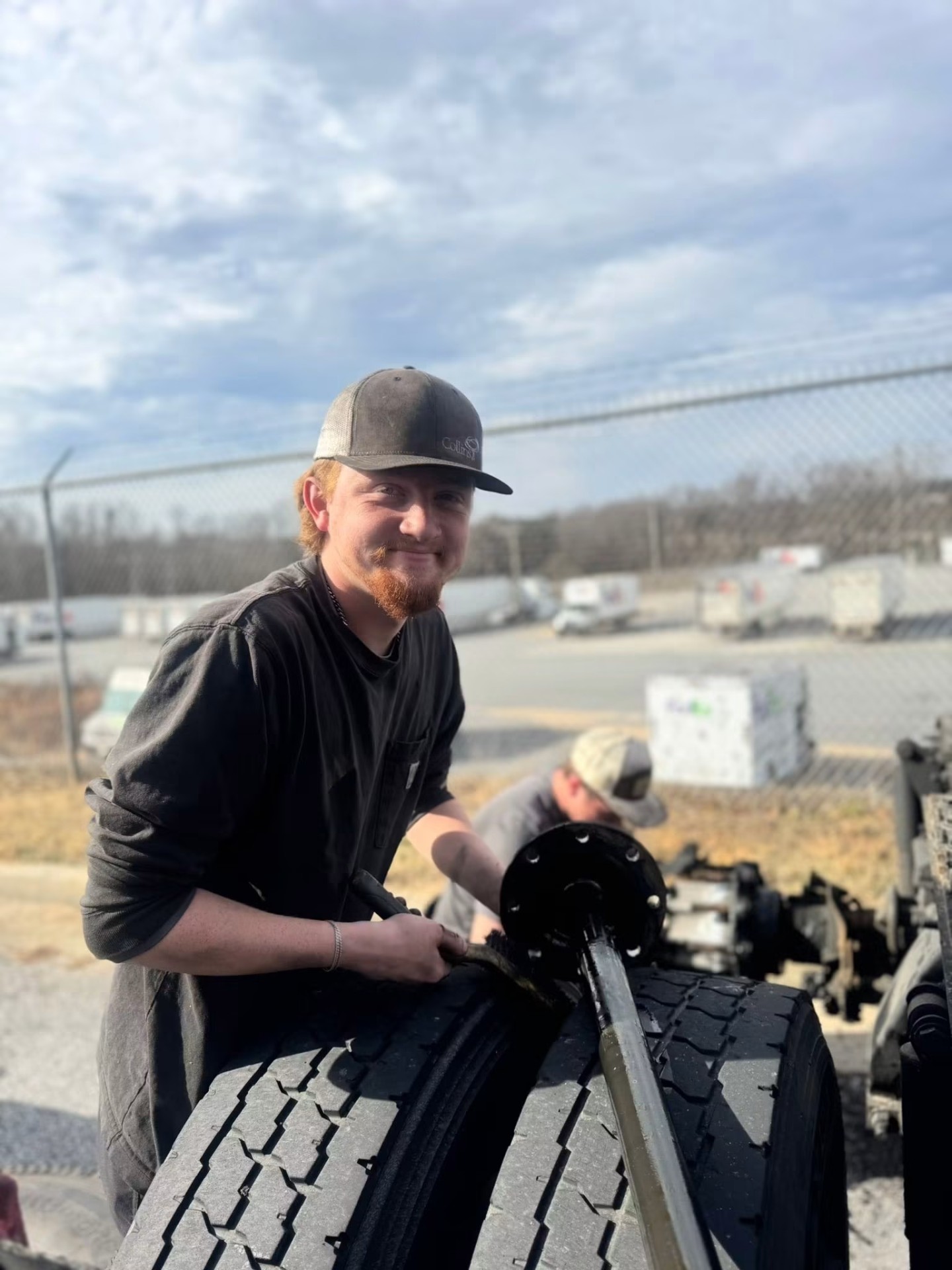 Tech servicing a heavy truck axle and hub outside the yard